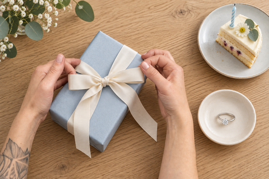 誕生日の小さなケーキ、一粒リング、リボンを結ぶ手元